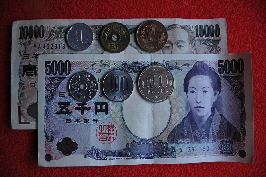 Kovové mince shora vlevo: 1 jen, 5 jenů, 10 jenů; dole zleva: 50 jenů, 100 jenů, 500 jenů